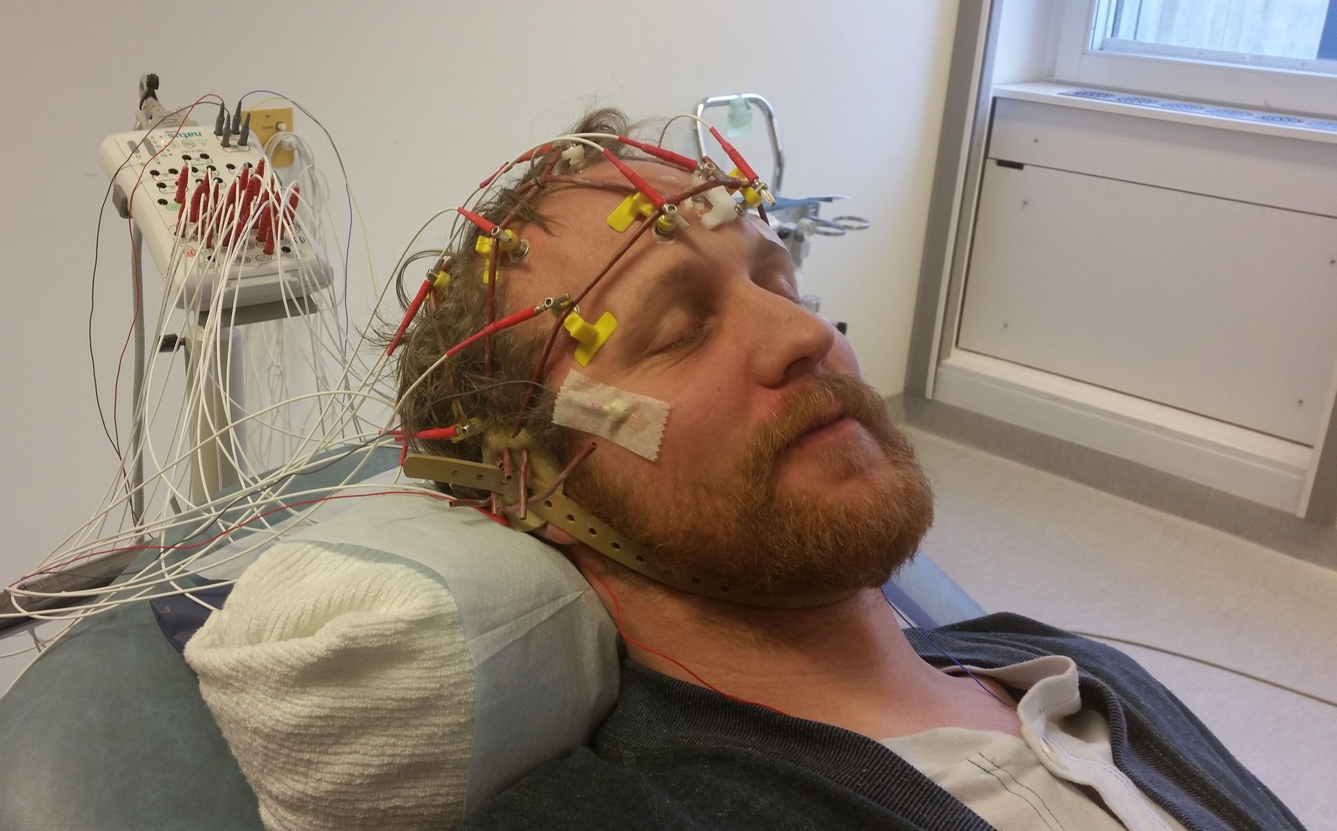 Close-Up Of Young Man With Medical Equipment On Bed At Hospital Ward